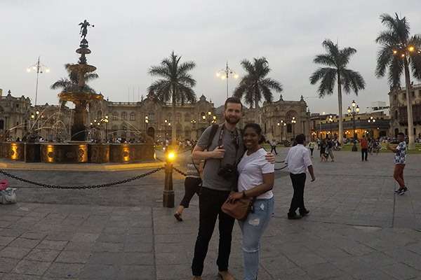 Couple posing in front of Perús Government Palace in the early evening