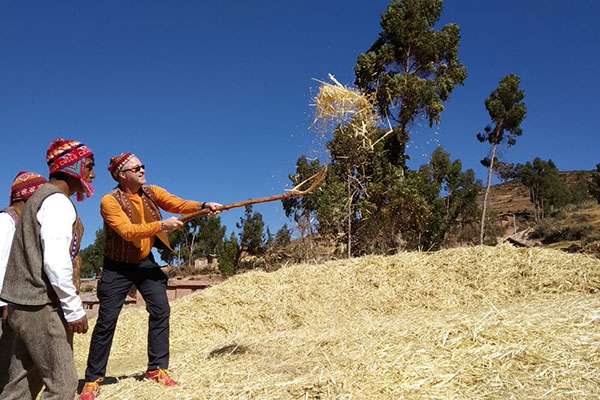 American man working with hay in andean village