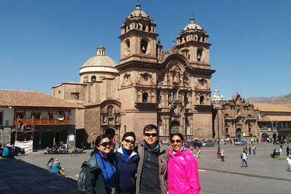 Travelers posing in front of Cusco's Cathedral