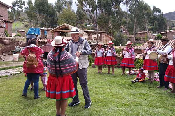 Visitor Dancing with villager in andean town