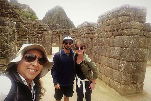 Selfie of Couple and Guide visiting Machu Picchu