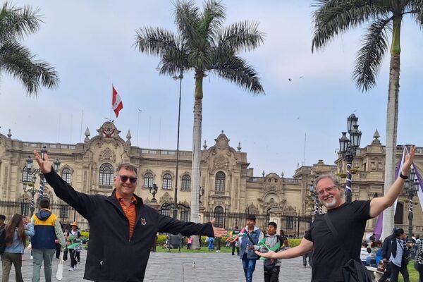 traveling friends posing in front of the Government Palace in Lima Peru